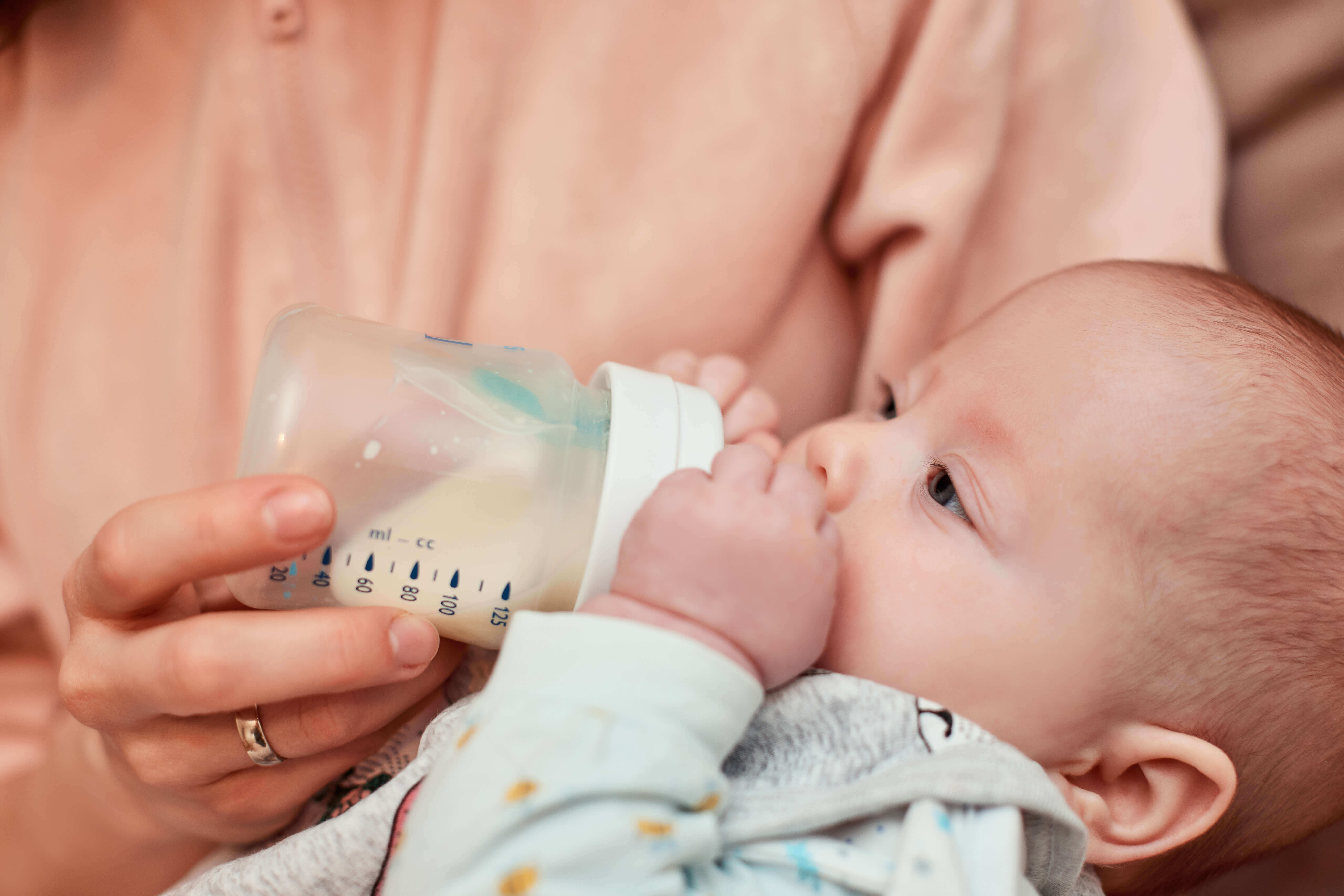 50461350 mother feeds little cute newborn daughter with milk bottle